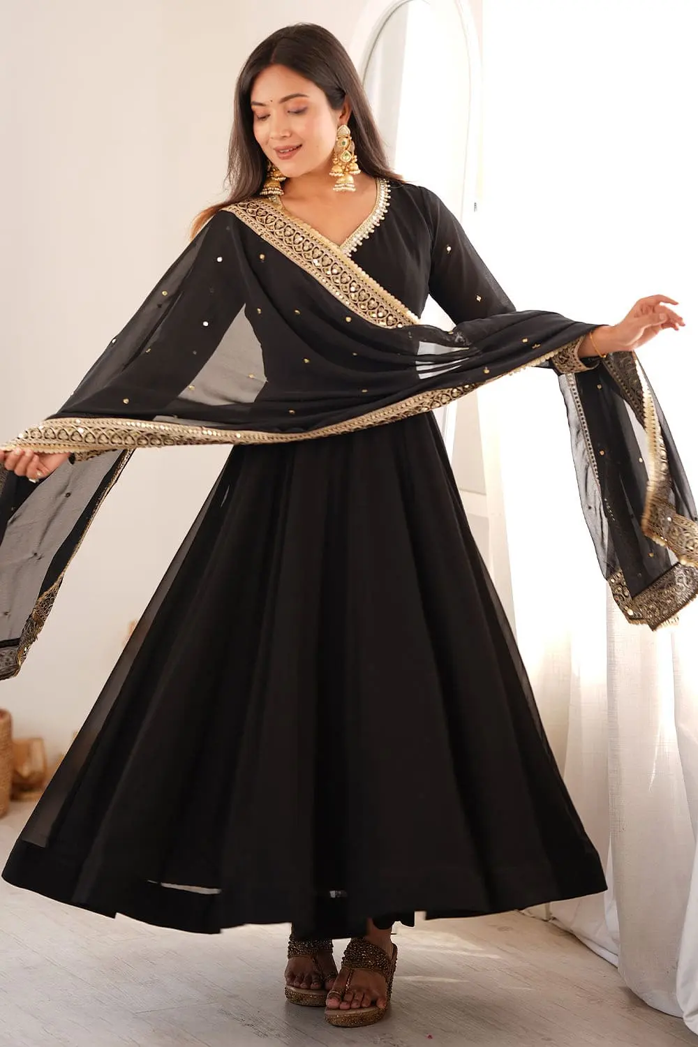 Front styling view of the flowing black georgette anarkali set.