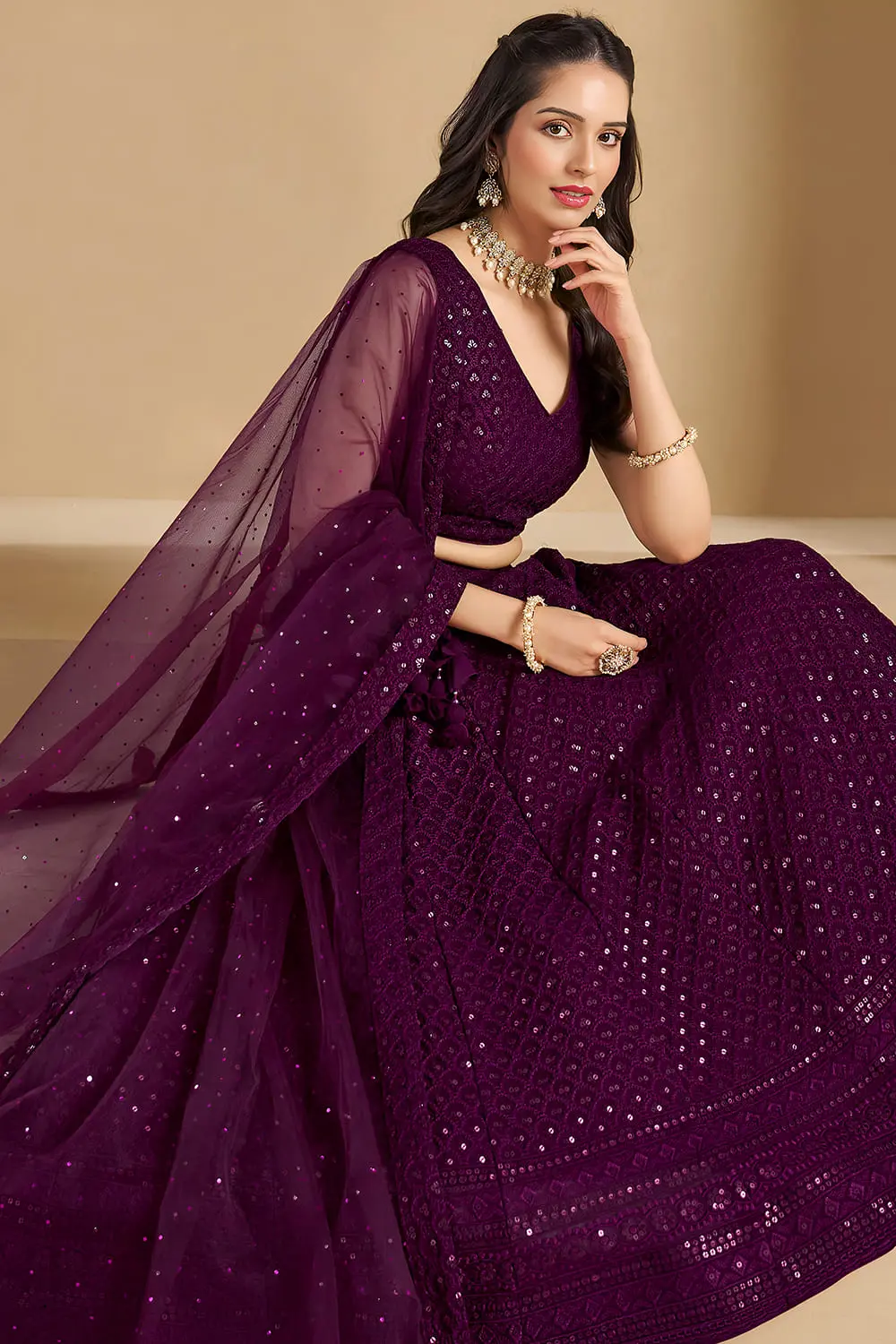 Elegantly seated woman showing the deep burgundy flare of the indian dress
