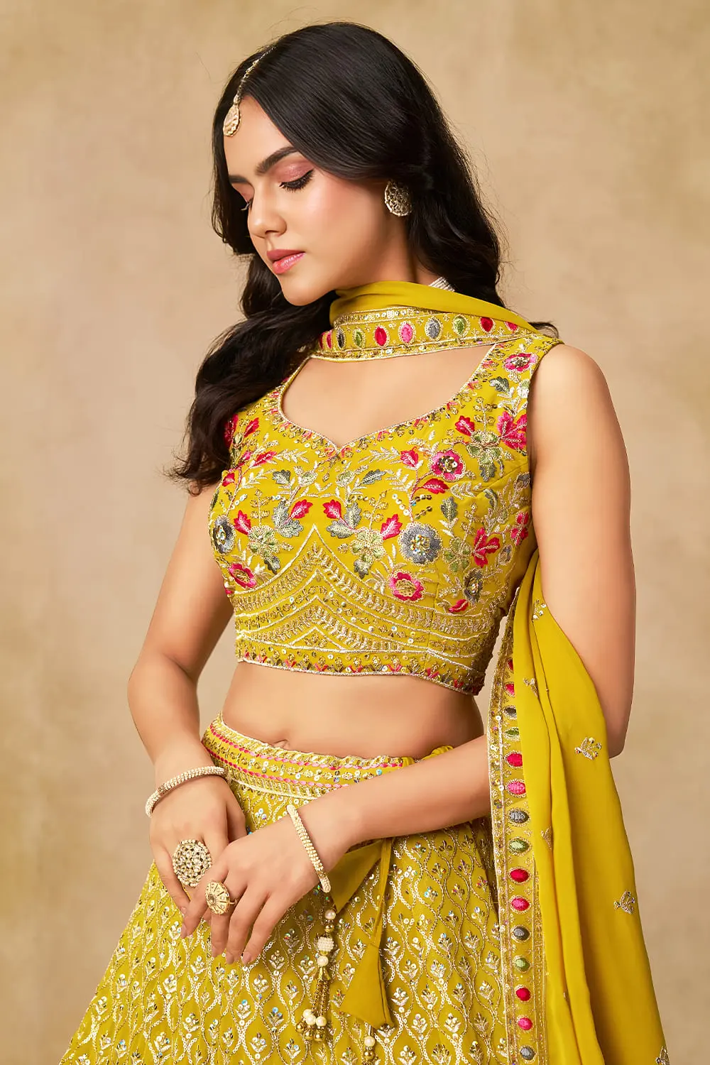 Close up of sequins and thread embroidery on yellow georgette lehenga